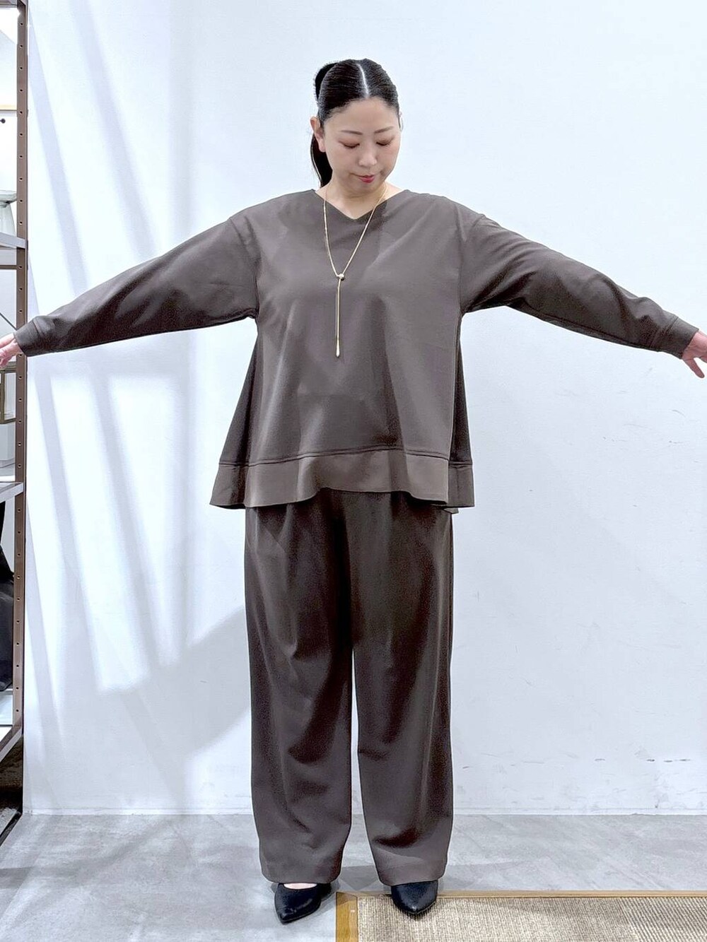 ブラウン系のその他パンツ、ブラウン系のTシャツ/カットソー、ブラック系のハンドバッグを着用したレディースの冬コーディネートの6枚目の写真