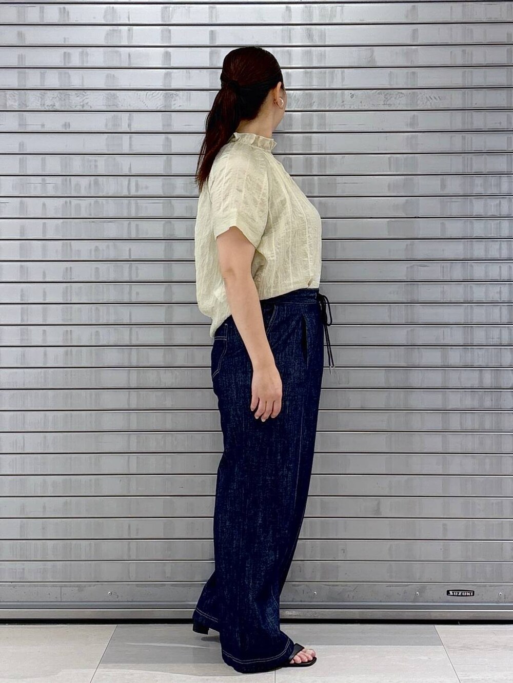 ブルー系のデニムパンツ、ブラック系のハンドバッグ、ホワイト系のシャツ/ブラウスを着用したレディースの夏コーディネートの4枚目の写真