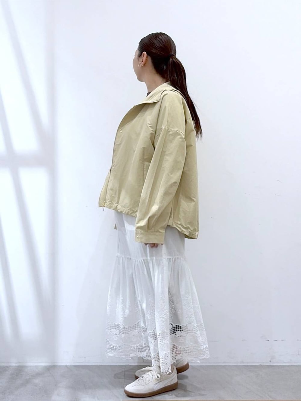 ブラウン系のTシャツ/カットソー、ブラック系のバックパック/リュック、ホワイト系のスカートを着用したレディースの春コーディネートの3枚目の写真