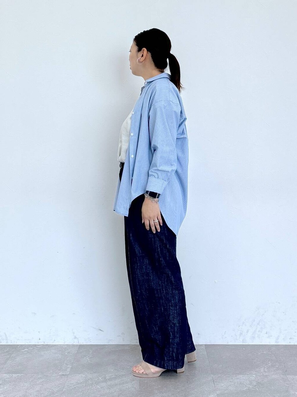 ブルー系のデニムパンツ、ホワイト系のシャツ/ブラウス、ベージュ系のサンダルを着用したレディースの夏コーディネートの3枚目の写真