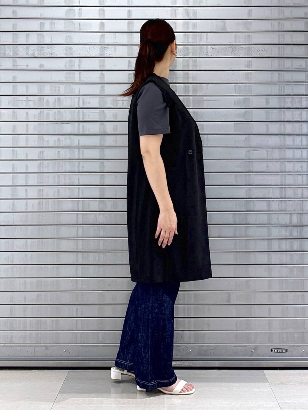 グレー系のTシャツ/カットソー、ブルー系のデニムパンツ、ホワイト系のハンドバッグを着用したレディースの春コーディネートの5枚目の写真