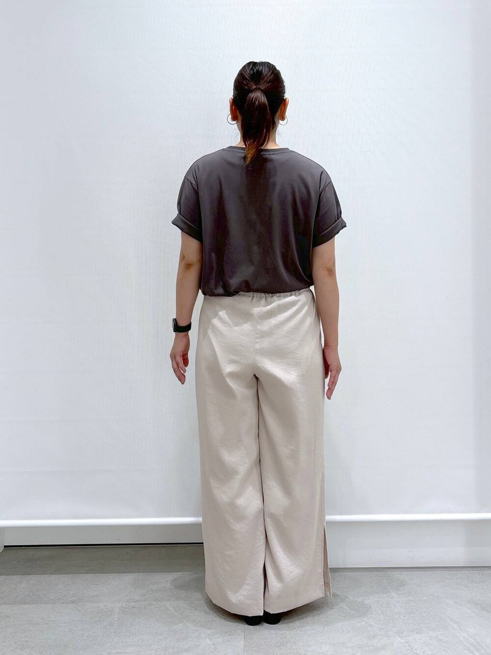 ベージュ系のその他パンツ、ブラック系のサンダル、グレー系のTシャツ/カットソーを着用したレディースの夏コーディネートの4枚目の写真