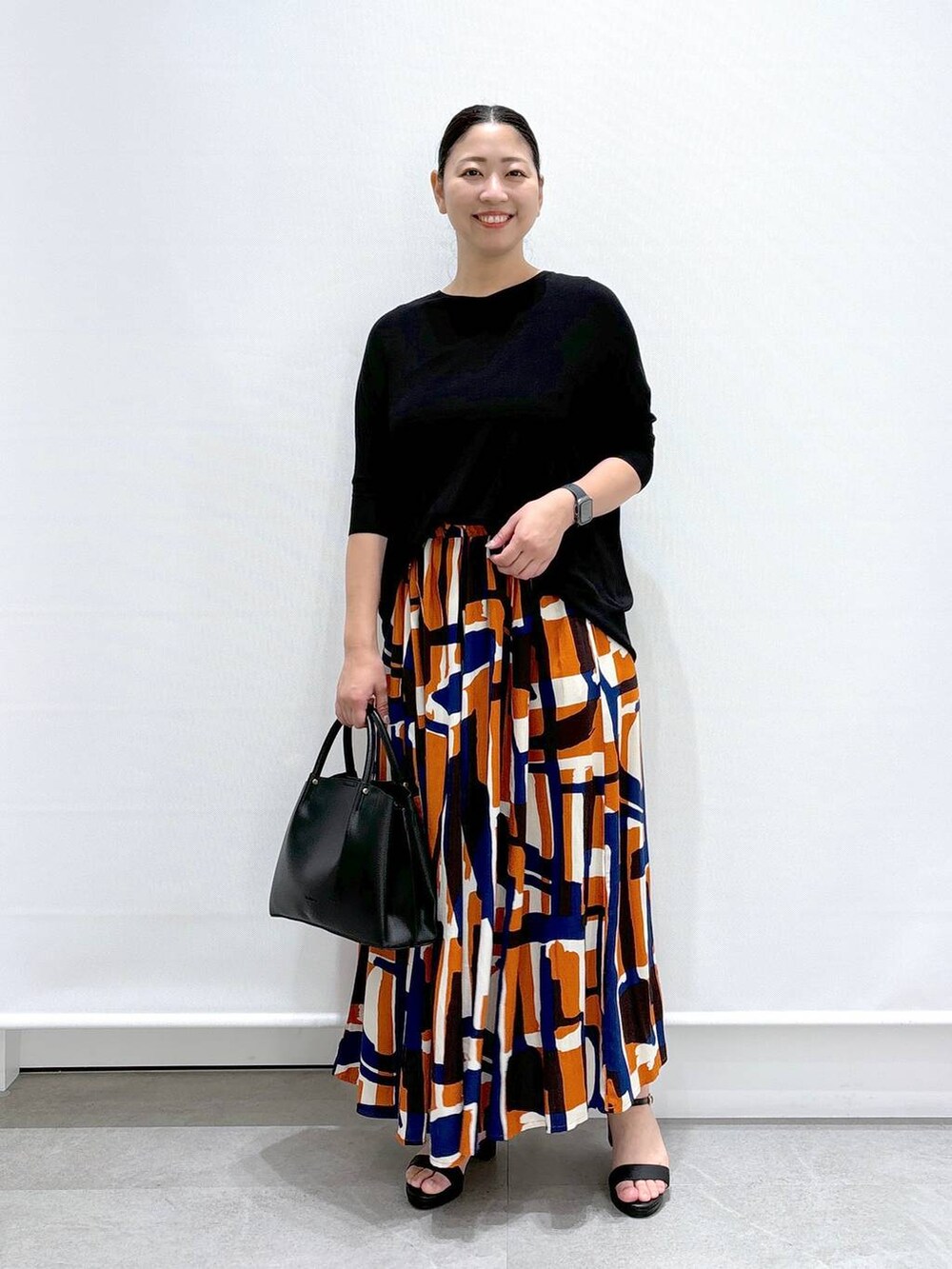 ブラック系のショルダーバッグ、ブラック系のサンダル、ブラック系のニット/セーターを着用したレディースの夏コーディネートの2枚目の写真