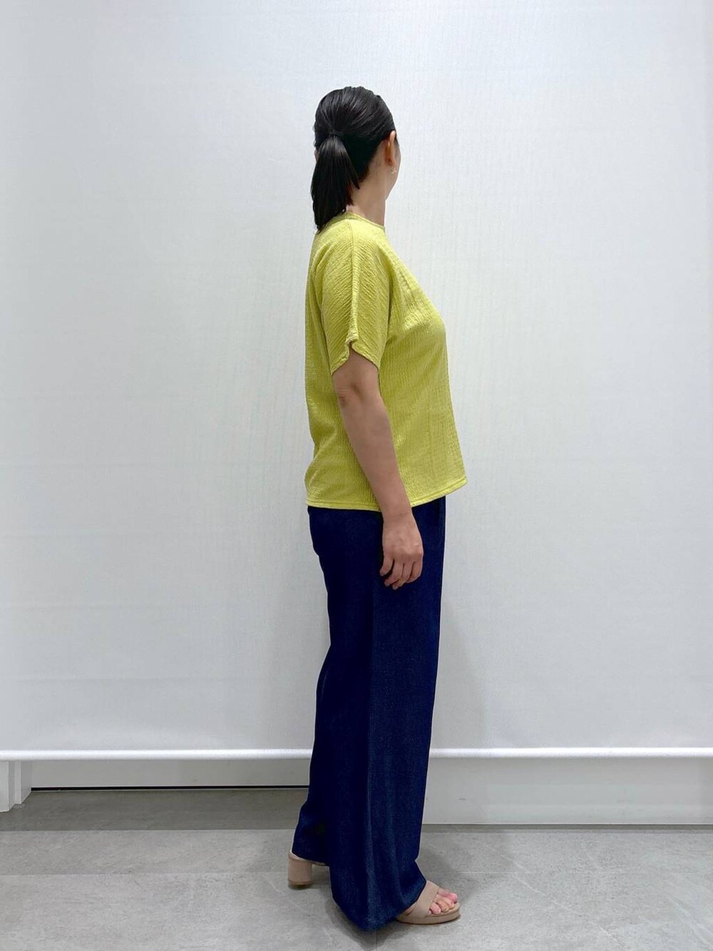 ホワイト系のトートバッグ、ベージュ系のサンダル、ブルー系のデニムパンツを着用したレディースの夏コーディネートの5枚目の写真