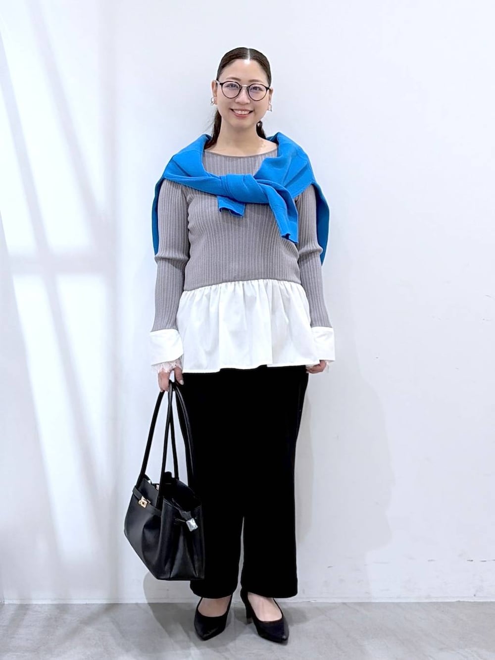 ブラック系のその他パンツ、ブラック系のハンドバッグ、ブルー系のカーディガン/ボレロを着用したレディースの春コーディネートの2枚目の写真