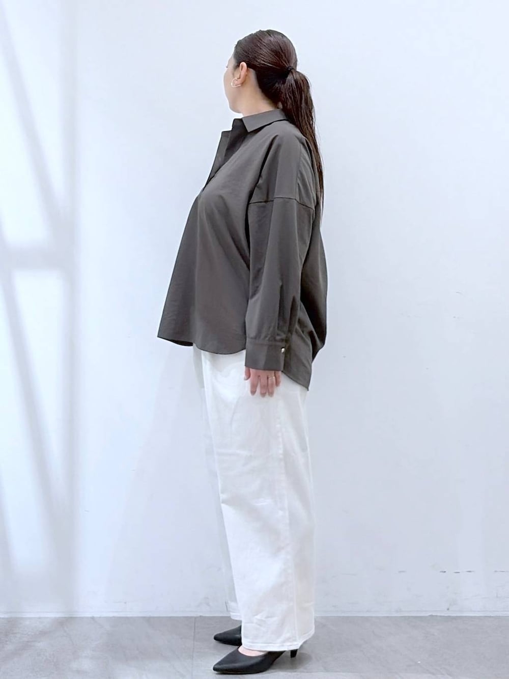 ホワイト系のデニムパンツ、ブラック系のハンドバッグ、ブラウン系のシャツ/ブラウスを着用したレディースの春コーディネートの3枚目の写真