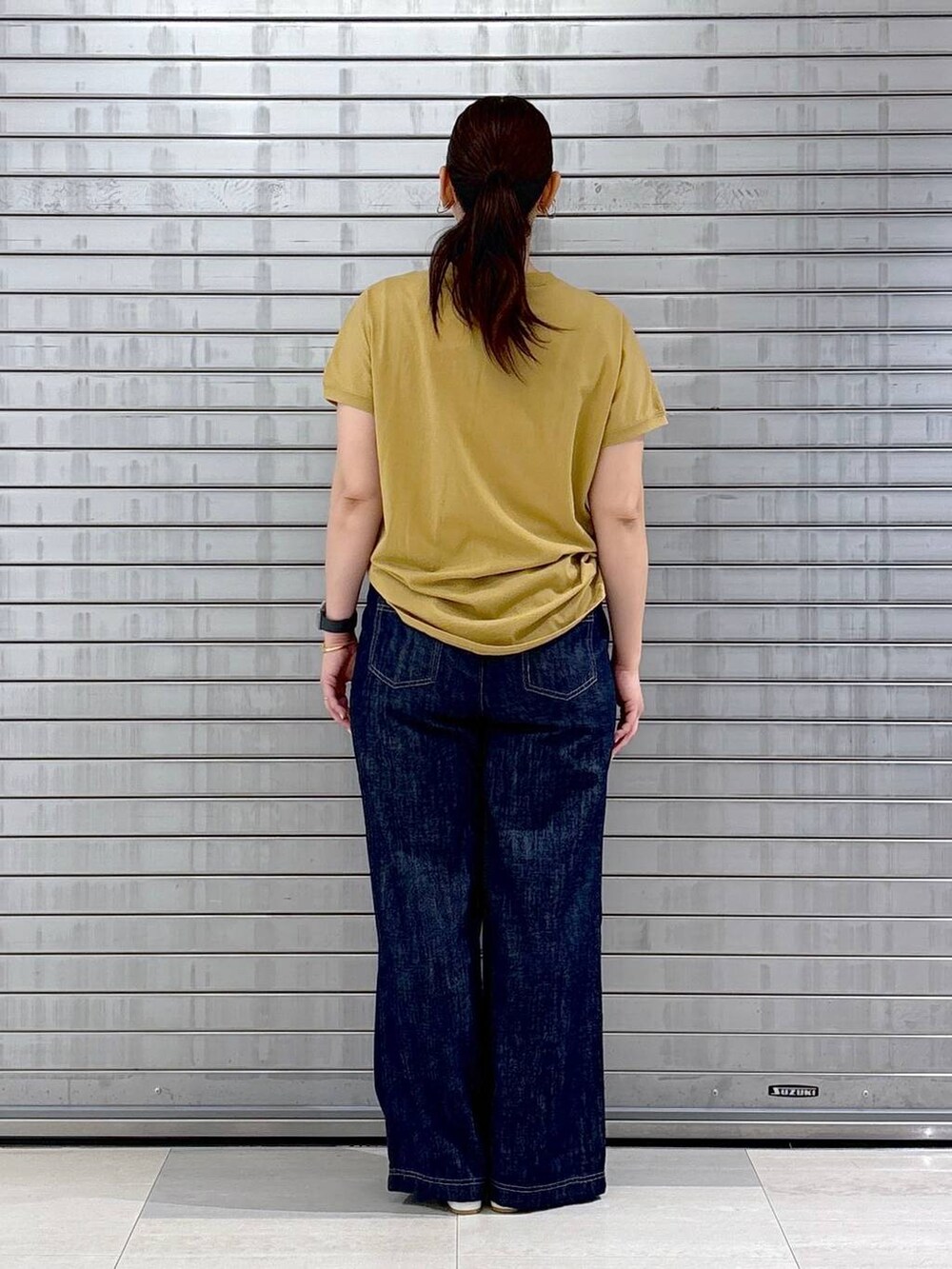 ブルー系のデニムパンツ、ホワイト系のハンドバッグ、イエロー系のTシャツ/カットソーを着用したレディースの春コーディネートの3枚目の写真