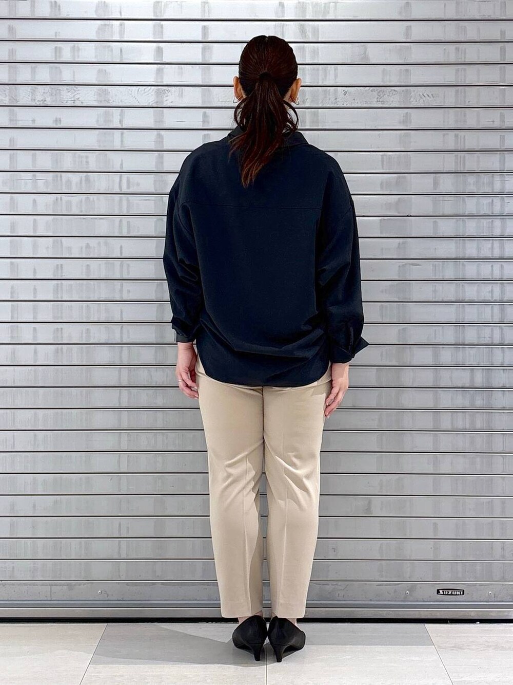 ブラック系のパンプス、ブルー系のシャツ/ブラウス、ブラック系のハンドバッグを着用したレディースの春コーディネートの4枚目の写真