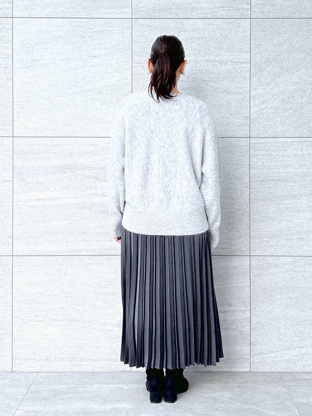 グレー系のブーツ、グレー系のスカート、グレー系のスカートを着用したレディースの秋コーディネートの4枚目の写真