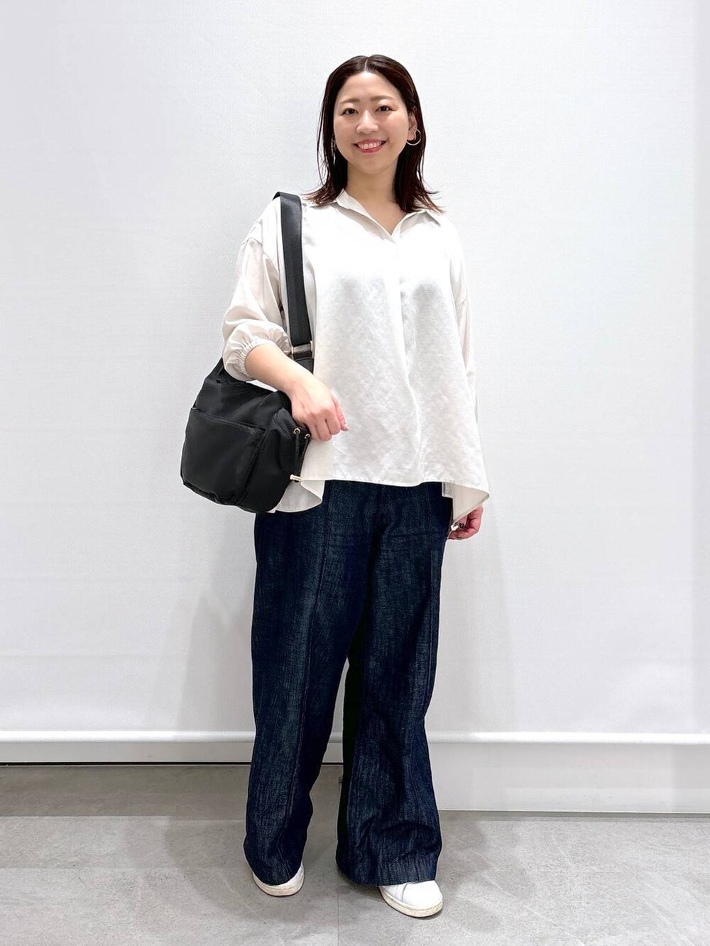 ブルー系のデニムパンツ、ホワイト系のTシャツ/カットソー、ブラック系のボディバッグ/ウエストポーチを着用したレディースの春コーディネートの2枚目の写真