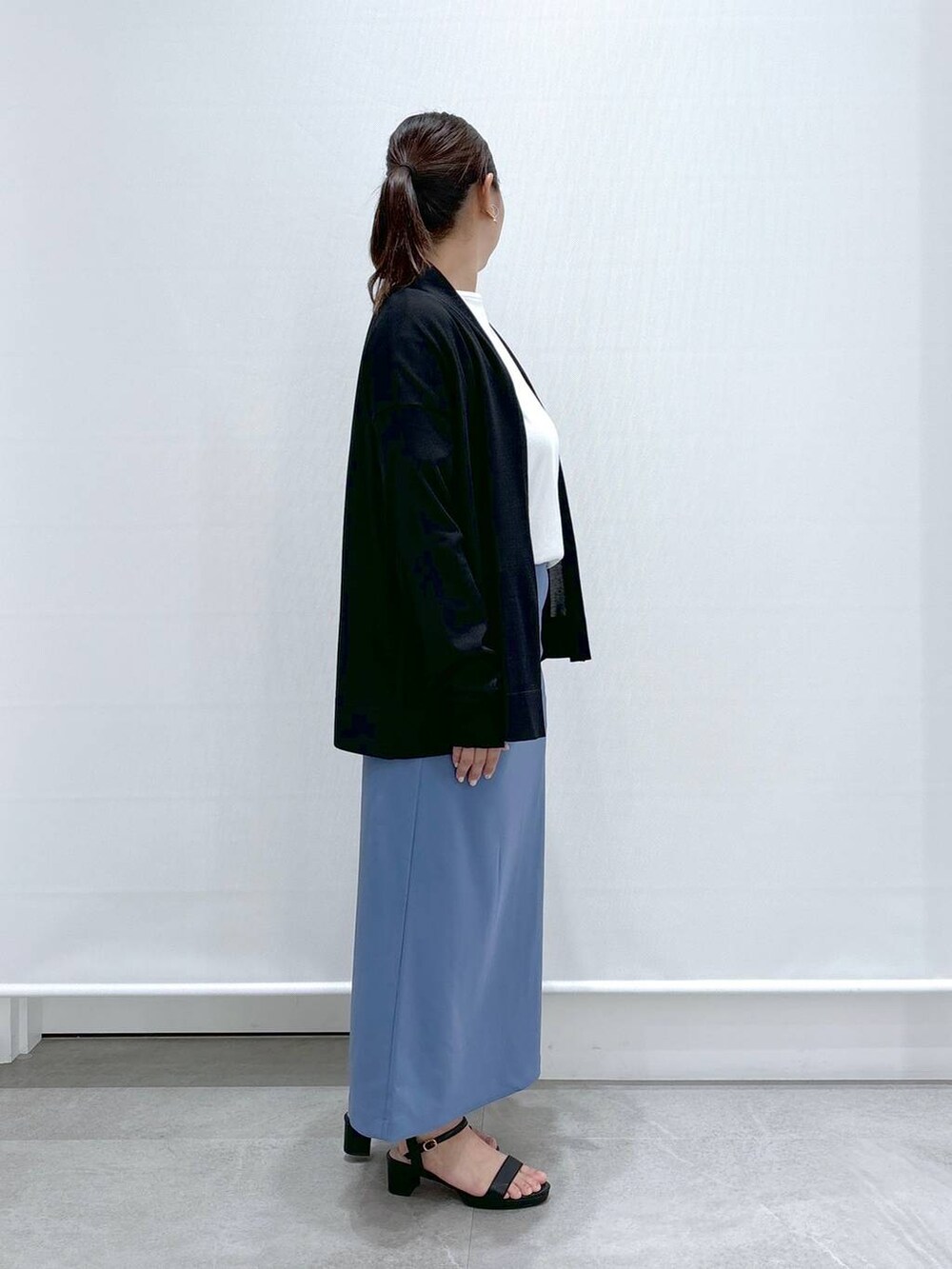 ブラック系のサンダル、ホワイト系のTシャツ/カットソー、ブルー系のスカートを着用したレディースの秋コーディネートの5枚目の写真