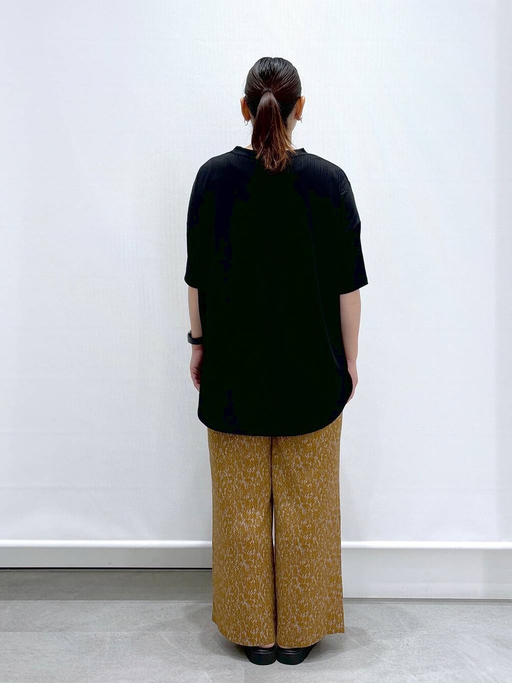 ブラック系のサンダル、ブラック系のTシャツ/カットソー、ブラック系のハンドバッグを着用したレディースの夏コーディネートの4枚目の写真