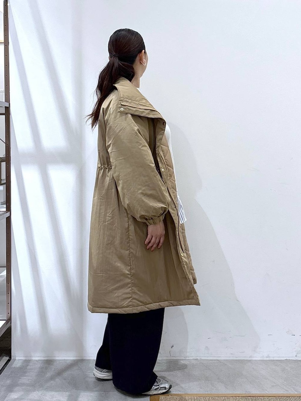 グレー系のスニーカー、イエロー系のダウンジャケット/コート、ベージュ系のTシャツ/カットソーを着用したレディースの秋コーディネートの8枚目の写真