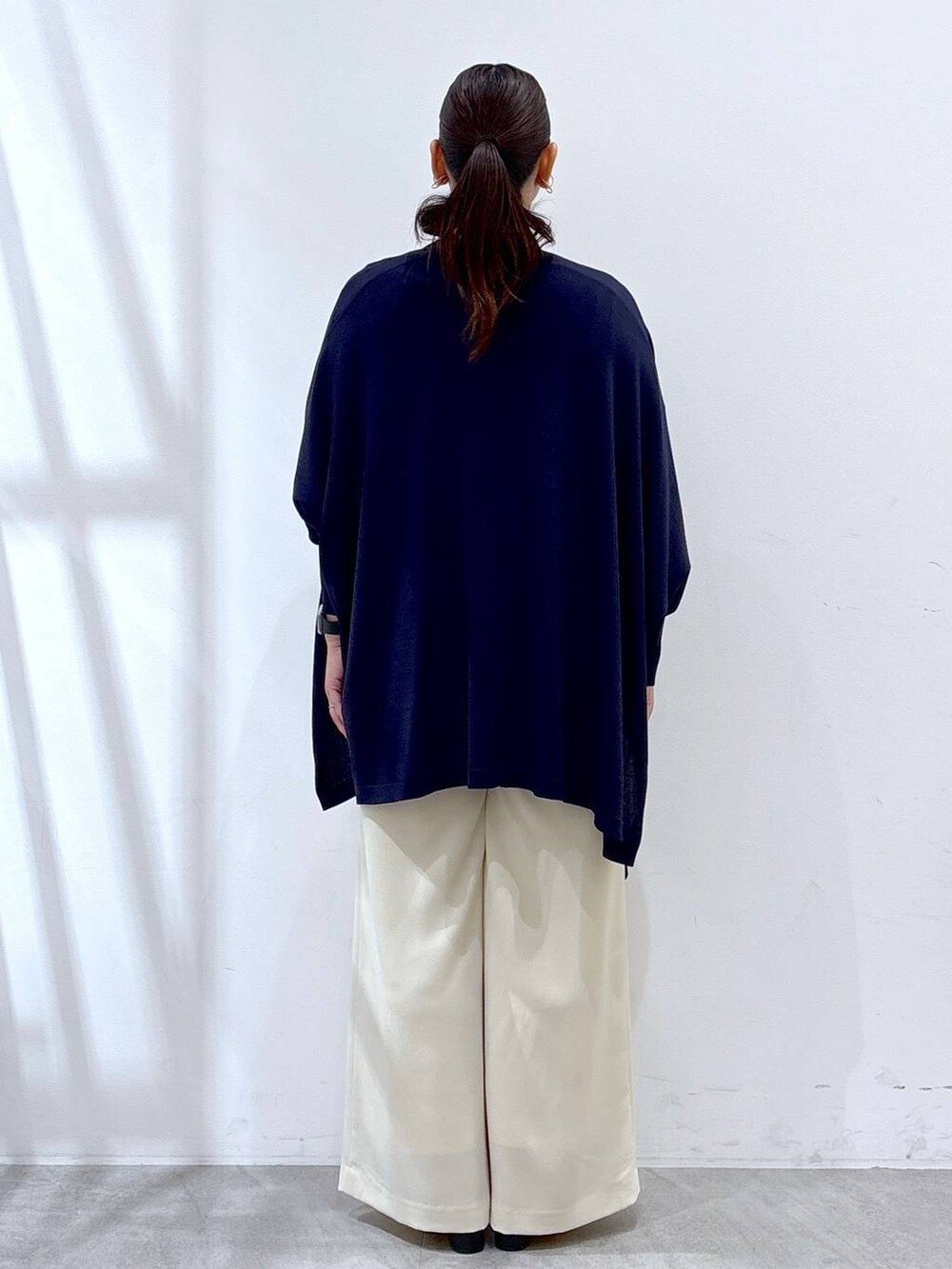 ブルー系のニット/セーター、ブルー系のカーディガン/ボレロ、ホワイト系のその他パンツを着用したレディースの春コーディネートの4枚目の写真