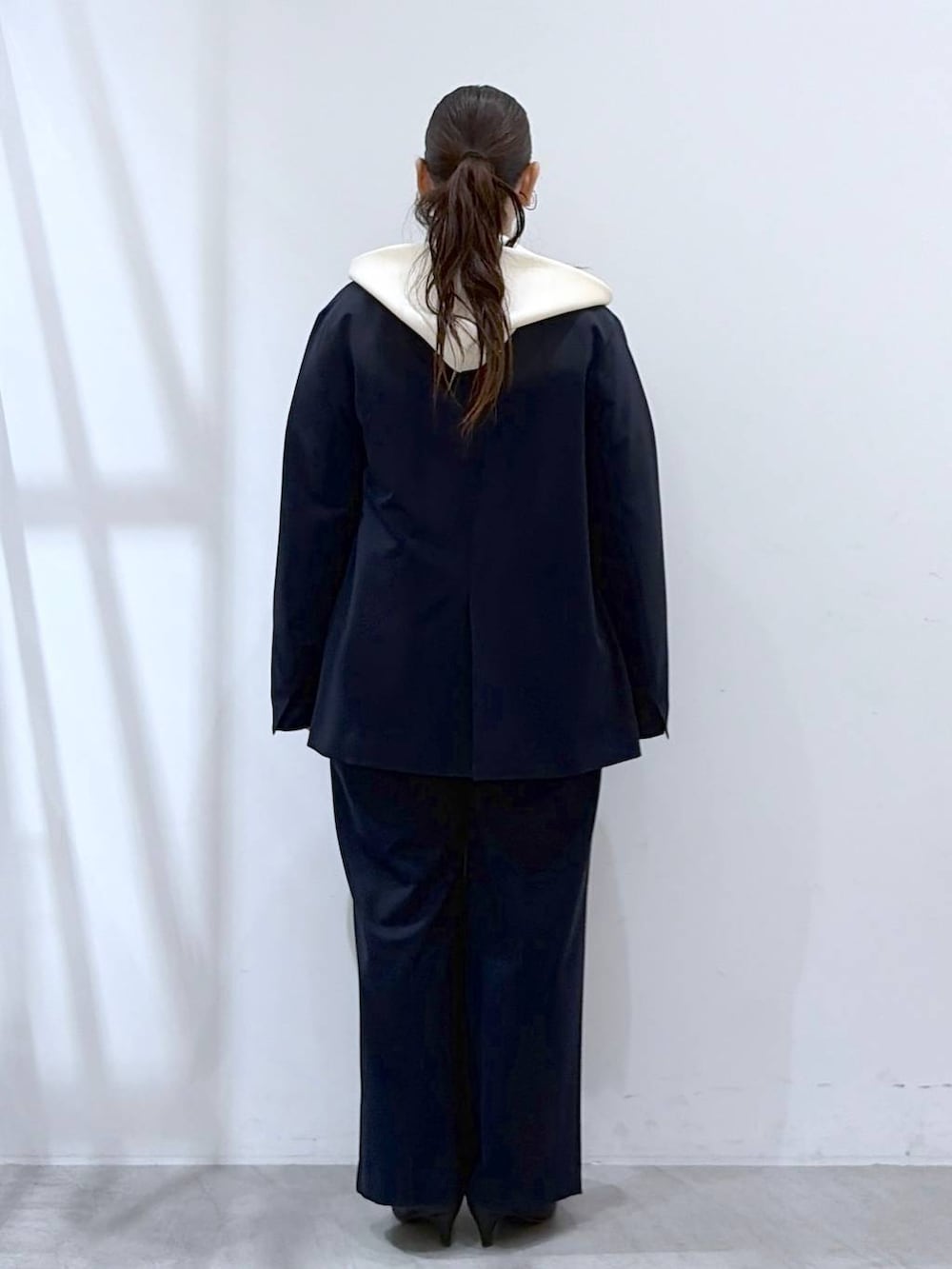 ブラック系のハンドバッグ、ホワイト系のパーカー、ブルー系のその他パンツを着用したレディースの春コーディネートの4枚目の写真