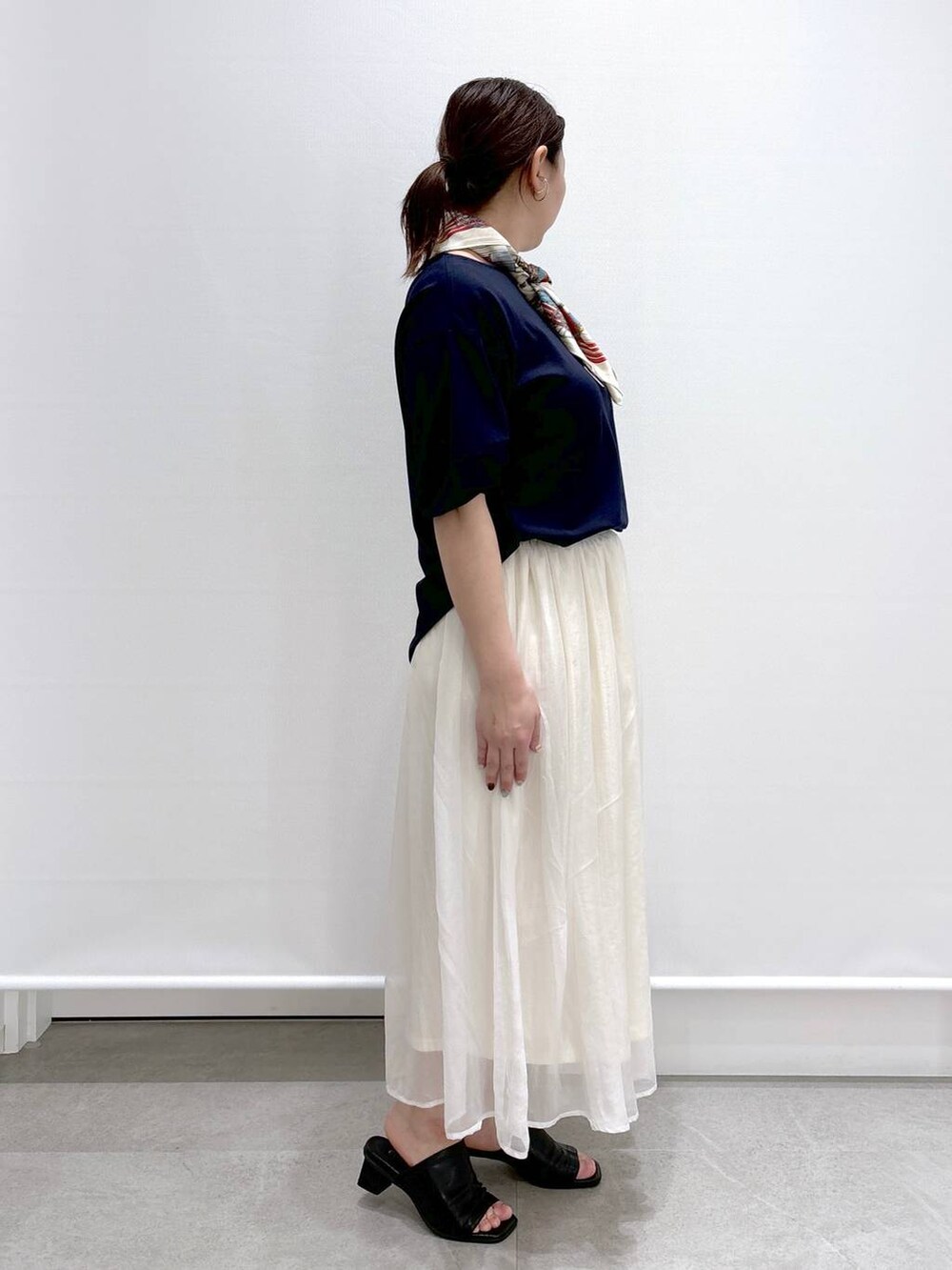 ホワイト系のスカート、ブラック系のショルダーバッグ、ブラック系のサンダルを着用したレディースの春コーディネートの4枚目の写真