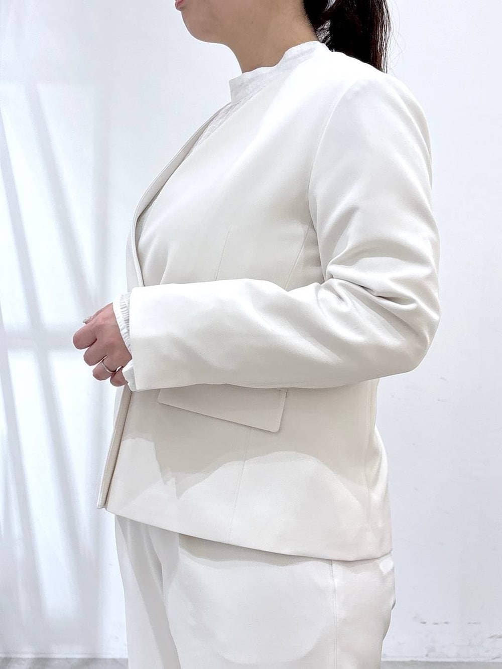 ブラック系のハンドバッグ、ホワイト系のシャツ/ブラウス、ホワイト系のノーカラージャケットを着用したレディースの春コーディネートの6枚目の写真