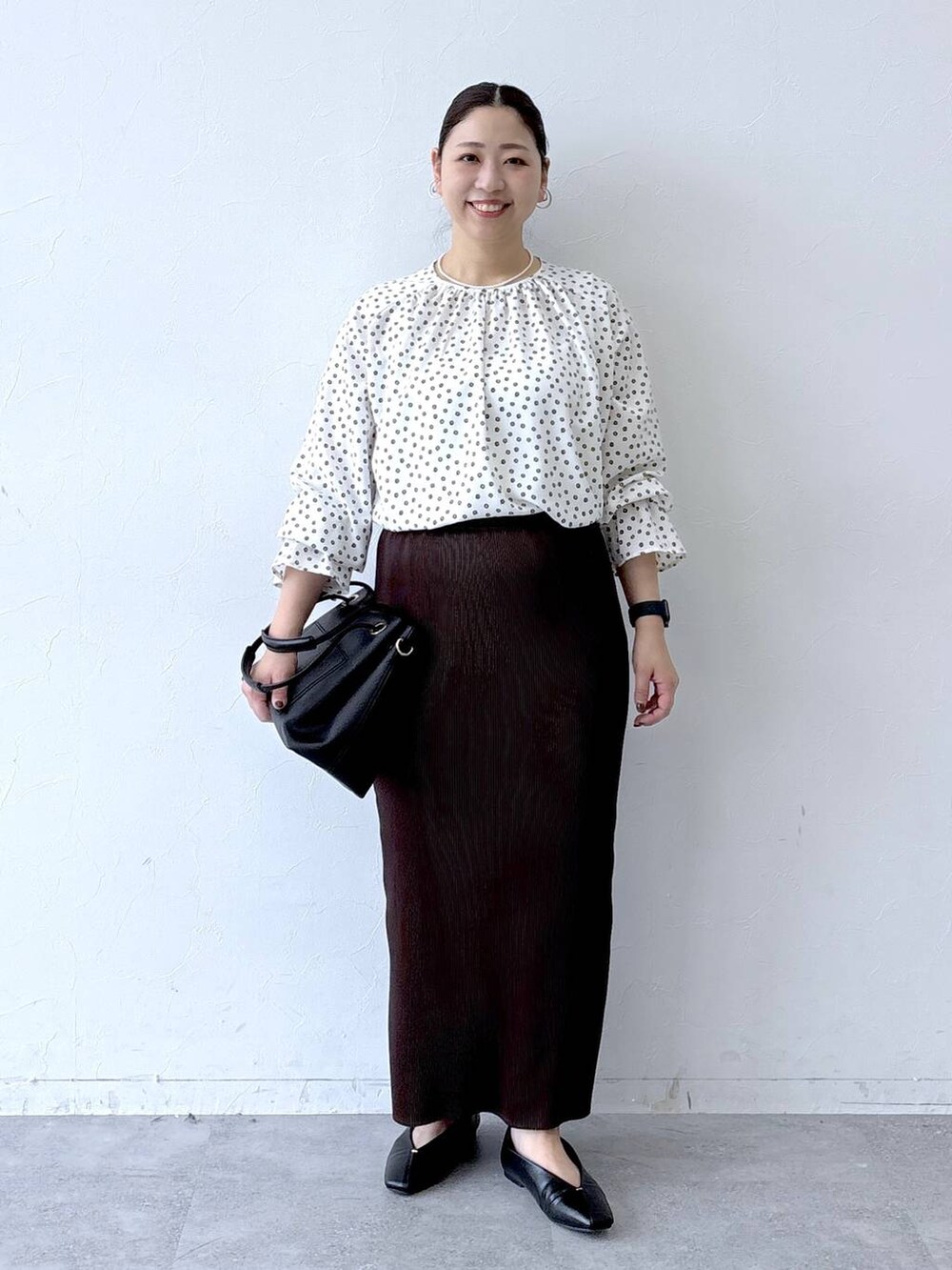 ブラック系のパンプス、ブラック系のトートバッグ、ホワイト系のシャツ/ブラウスを着用したレディースの冬コーディネートの2枚目の写真