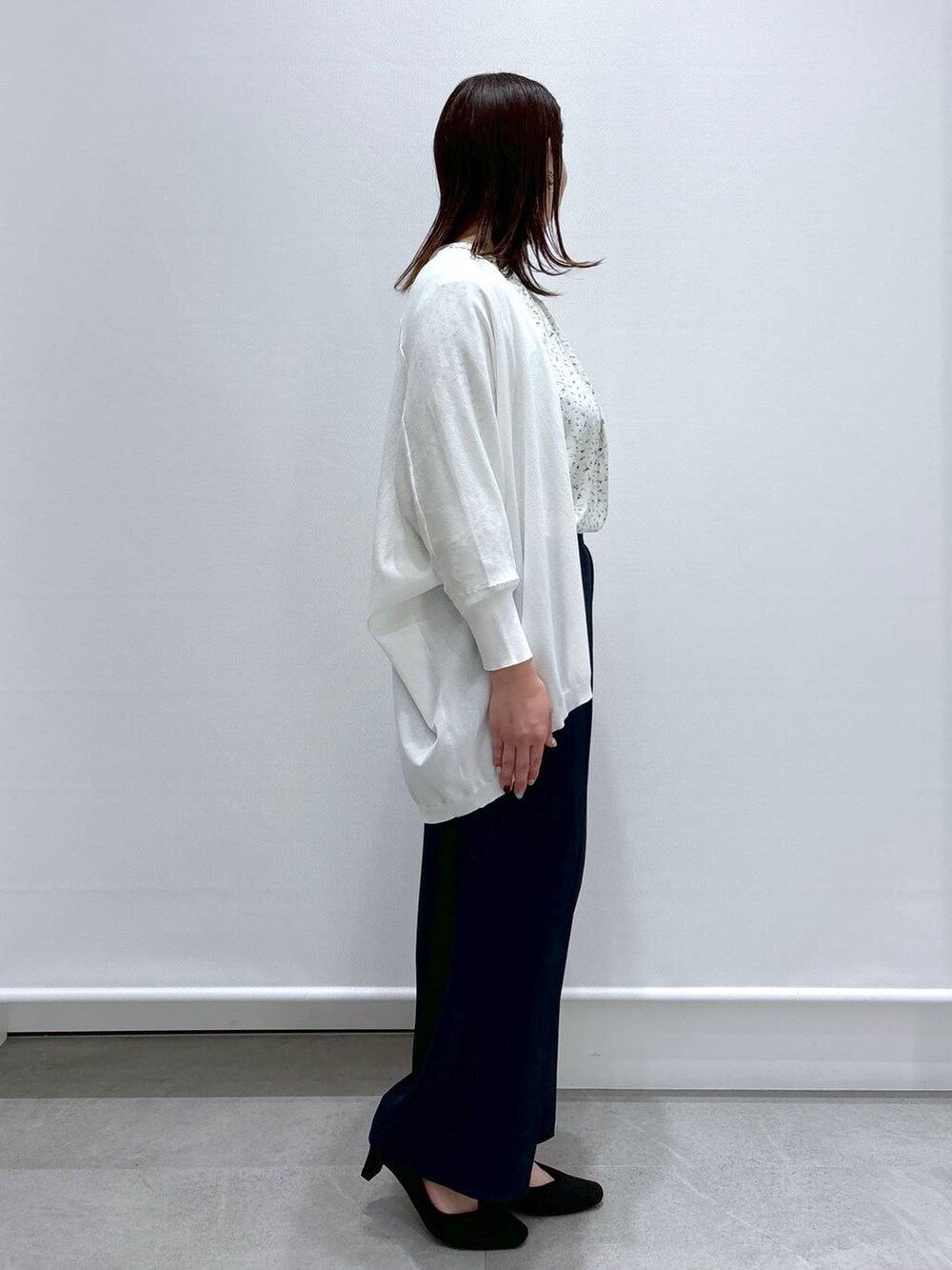 イエロー系のシャツ/ブラウス、ホワイト系のカーディガン/ボレロ、ブラック系のハンドバッグを着用したレディースの春コーディネートの5枚目の写真