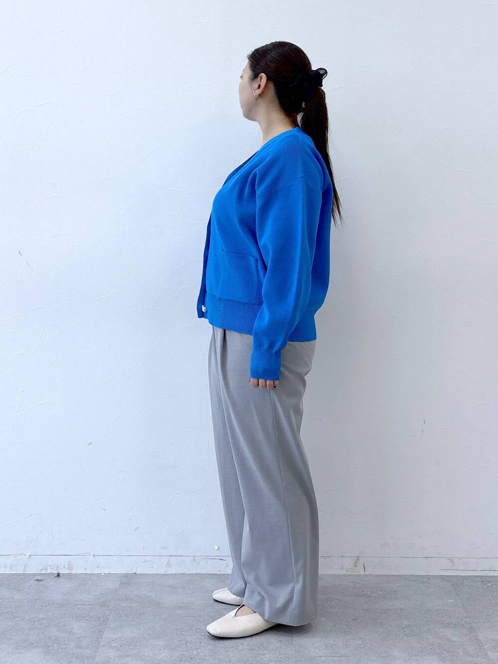 ホワイト系のパンプス、ホワイト系のハンドバッグ、グレー系のその他パンツを着用したレディースの冬コーディネートの3枚目の写真