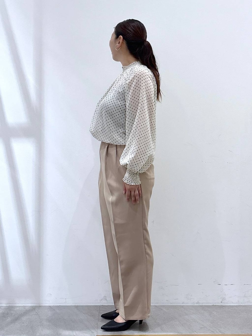 ブラック系のパンプス、ブラック系のカーディガン/ボレロ、ブラック系のハンドバッグを着用したレディースの秋コーディネートの4枚目の写真