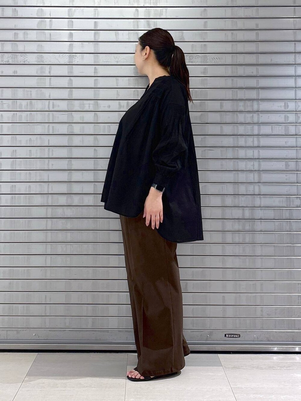 ブラック系のシャツ/ブラウス、ブラック系のハンドバッグ、ブラウン系のその他パンツを着用したレディースの春コーディネートの3枚目の写真