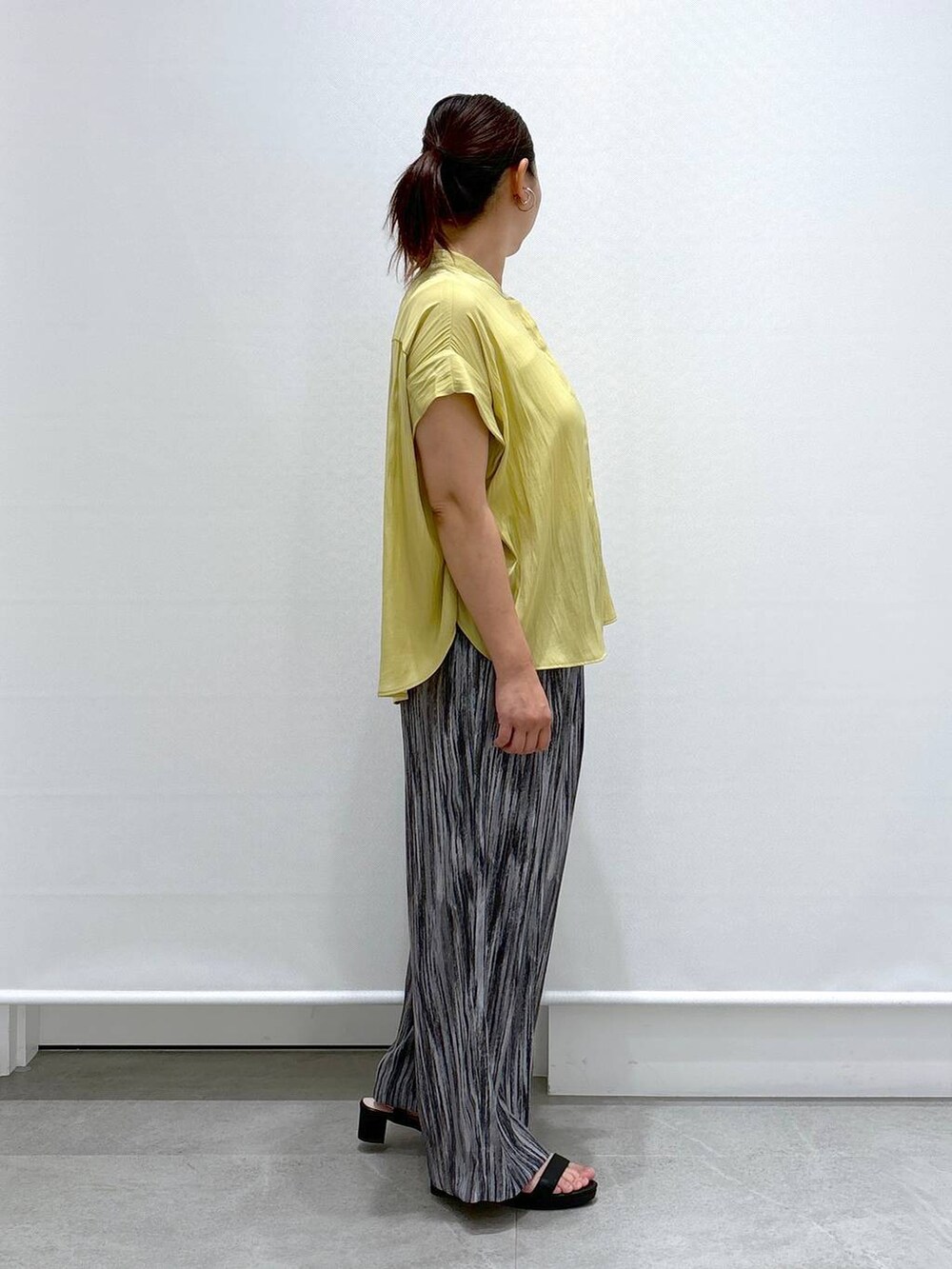 グレー系のその他パンツ、ブラック系のハンドバッグ、イエロー系のシャツ/ブラウスを着用したレディースの夏コーディネートの5枚目の写真
