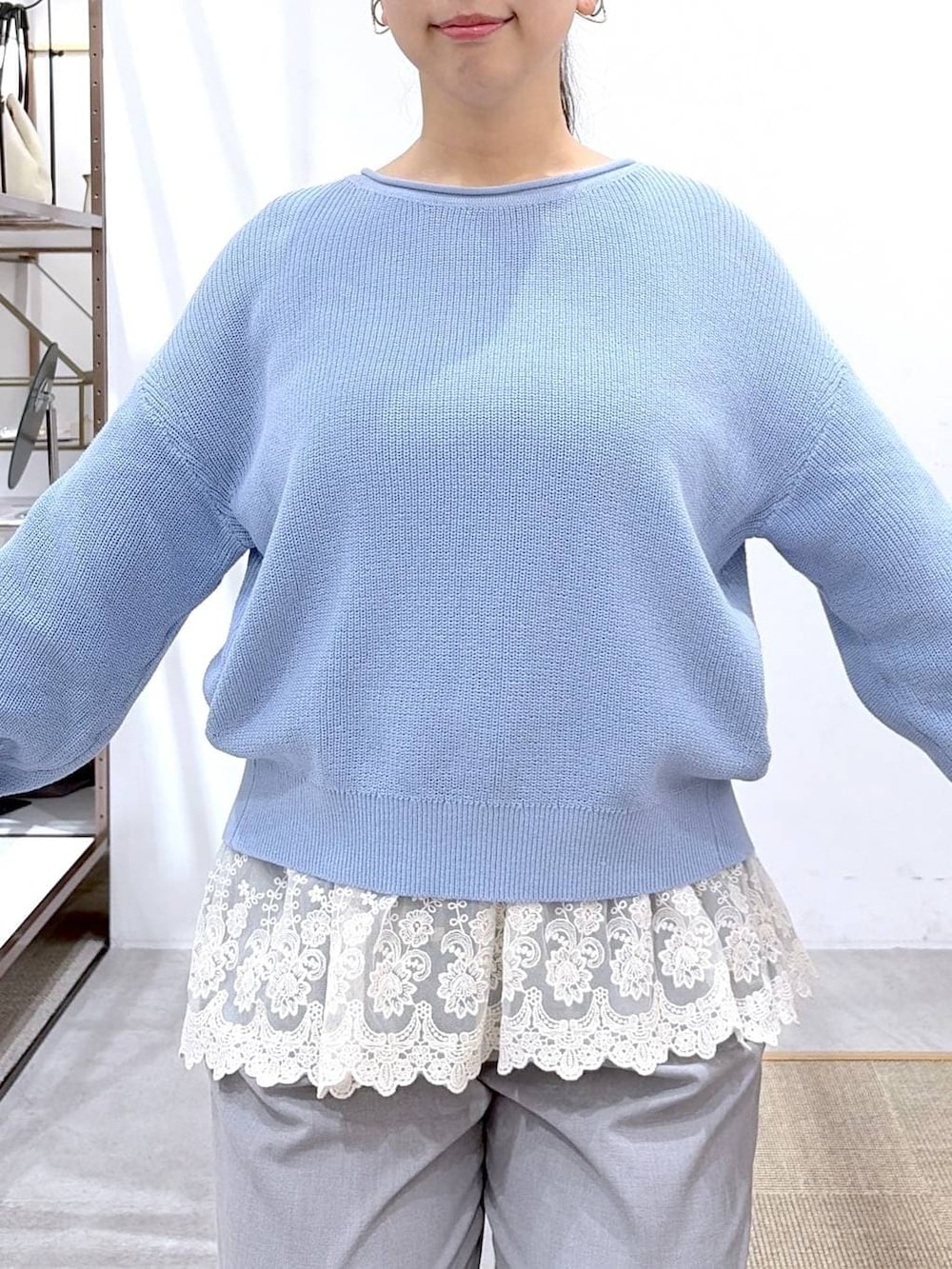 ブルー系のニット/セーター、ホワイト系のタンクトップ、ブラック系のハンドバッグを着用したレディースの春コーディネートの6枚目の写真