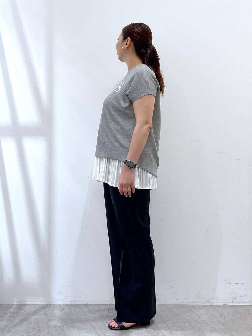 ホワイト系のタンクトップ、ブラック系のハンドバッグ、ブラック系のその他パンツを着用したレディースの夏コーディネートの3枚目の写真