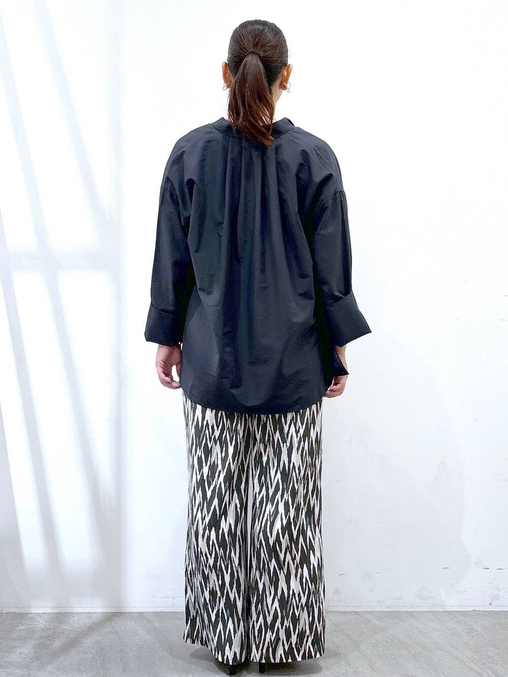 ブルー系のシャツ/ブラウス、ブラック系のトートバッグ、ブラック系のその他パンツを着用したレディースの秋コーディネートの4枚目の写真