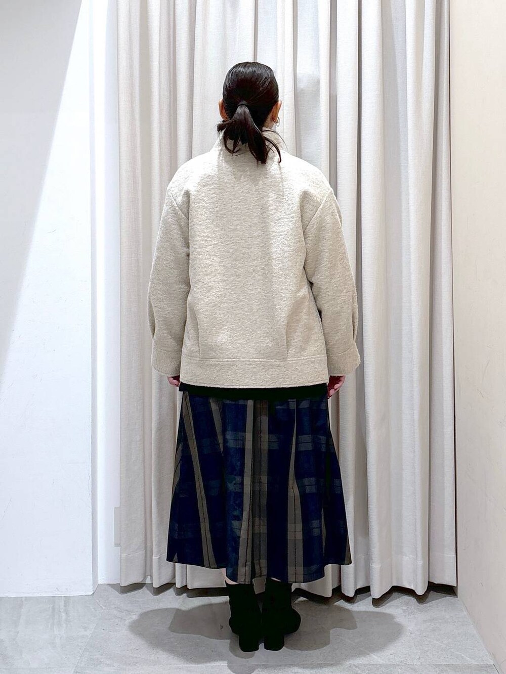 ブラック系のTシャツ/カットソー、グレー系のブーツ、ブラウン系のスカートを着用したレディースの冬コーディネートの4枚目の写真