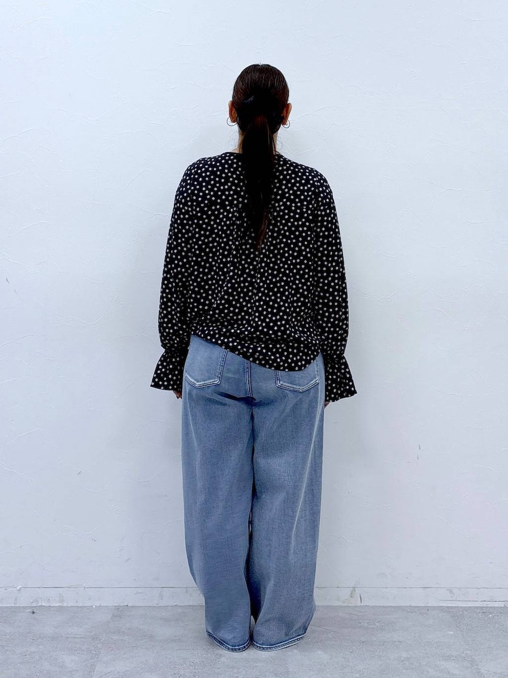 ブラック系のハンドバッグ、ブルー系のデニムパンツ、ブラック系のシャツ/ブラウスを着用したレディースの春コーディネートの4枚目の写真