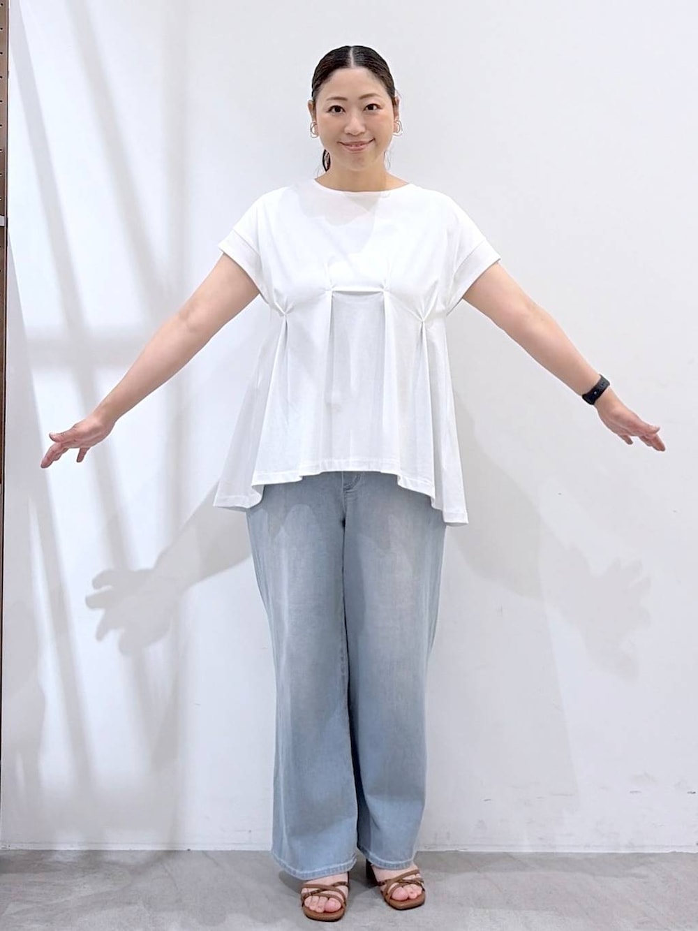 ブラウン系のサンダル、ブラウン系のハンドバッグ、ホワイト系のTシャツ/カットソーを着用したレディースの夏コーディネートの6枚目の写真