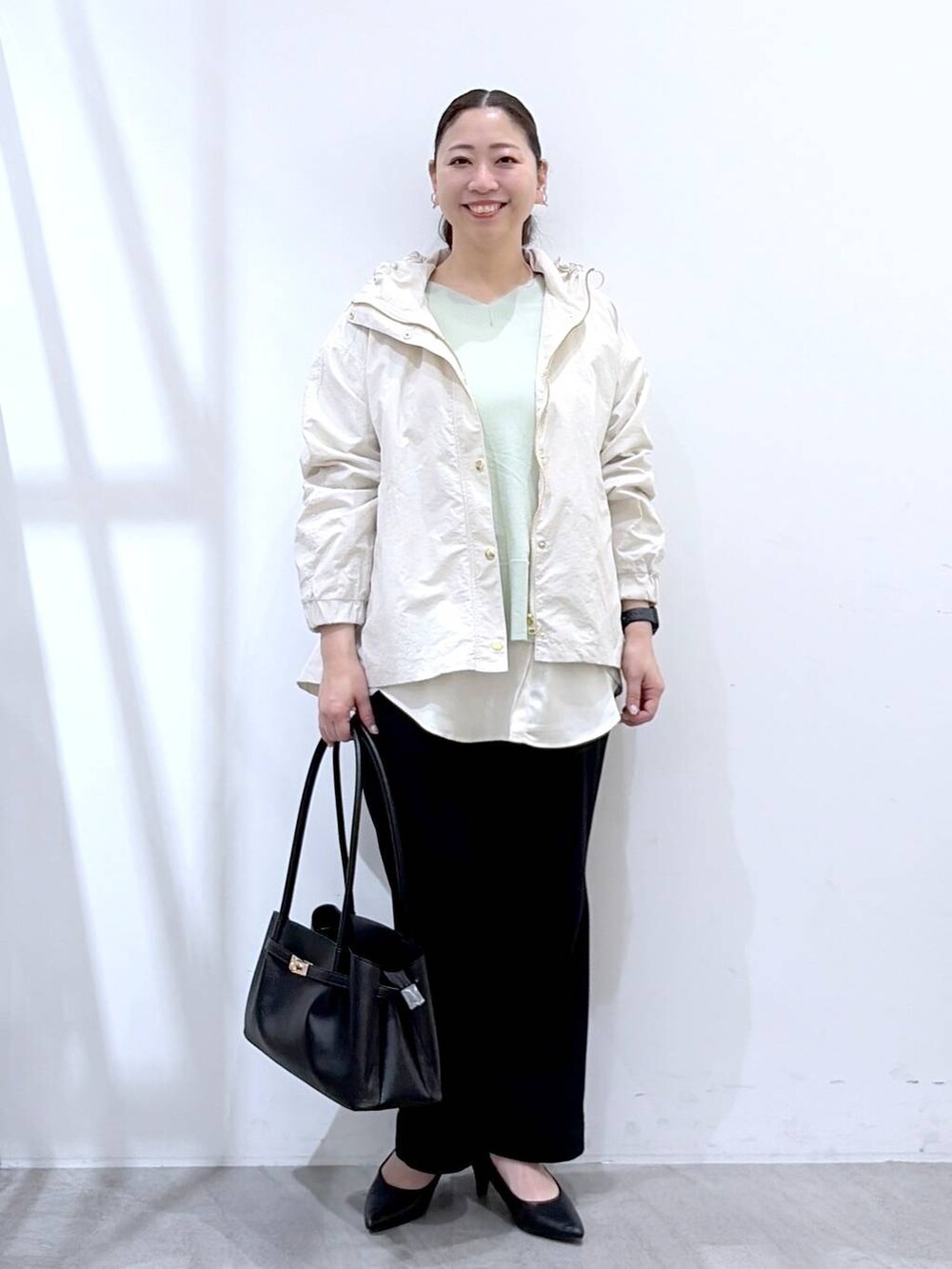 ホワイト系のその他パンツ、ブラック系のハンドバッグ、グリーン系のTシャツ/カットソーを着用したレディースの春コーディネートの2枚目の写真