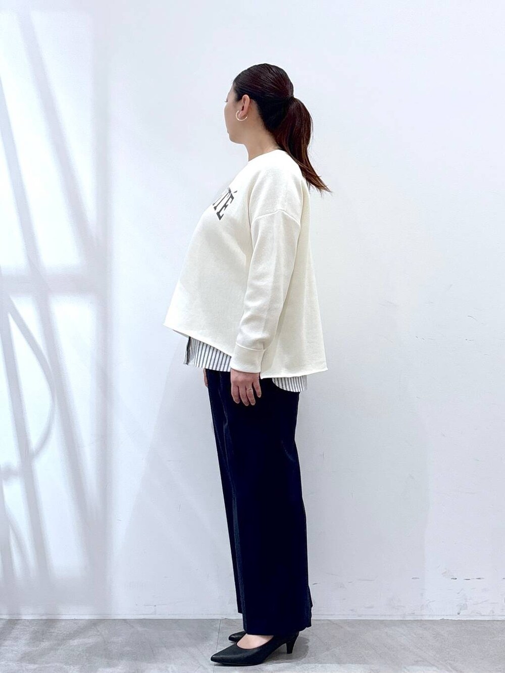 ホワイト系のニット/セーター、ブラック系のタンクトップ、ブルー系のその他パンツを着用したレディースの春コーディネートの3枚目の写真