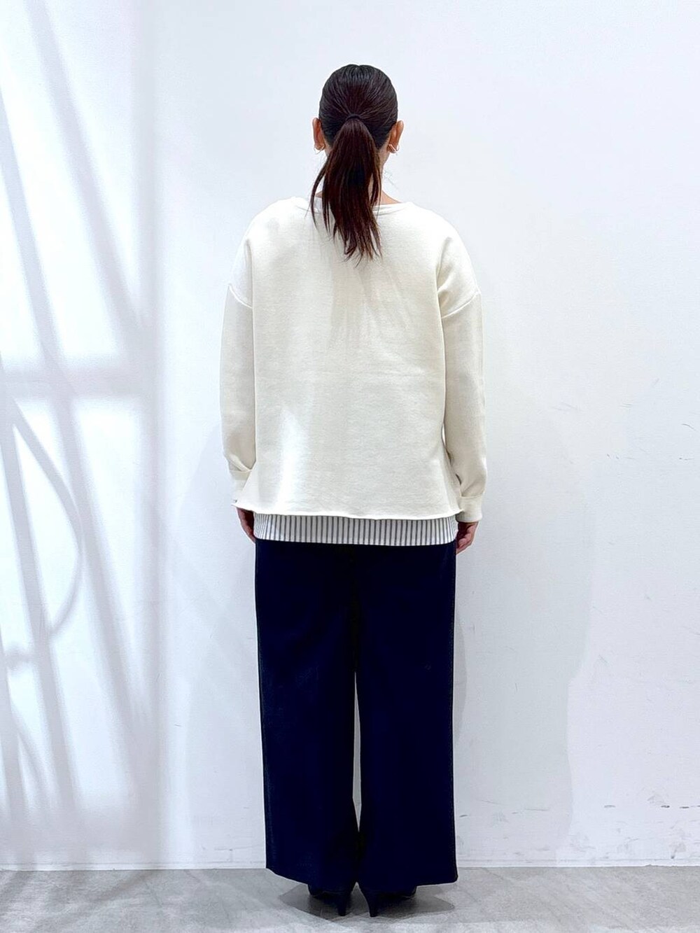 ホワイト系のニット/セーター、ブラック系のタンクトップ、ブルー系のその他パンツを着用したレディースの春コーディネートの4枚目の写真