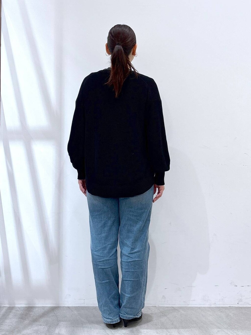 ブルー系のデニムパンツ、ブラック系のカーディガン/ボレロ、グレー系のTシャツ/カットソーを着用したレディースの春コーディネートの4枚目の写真