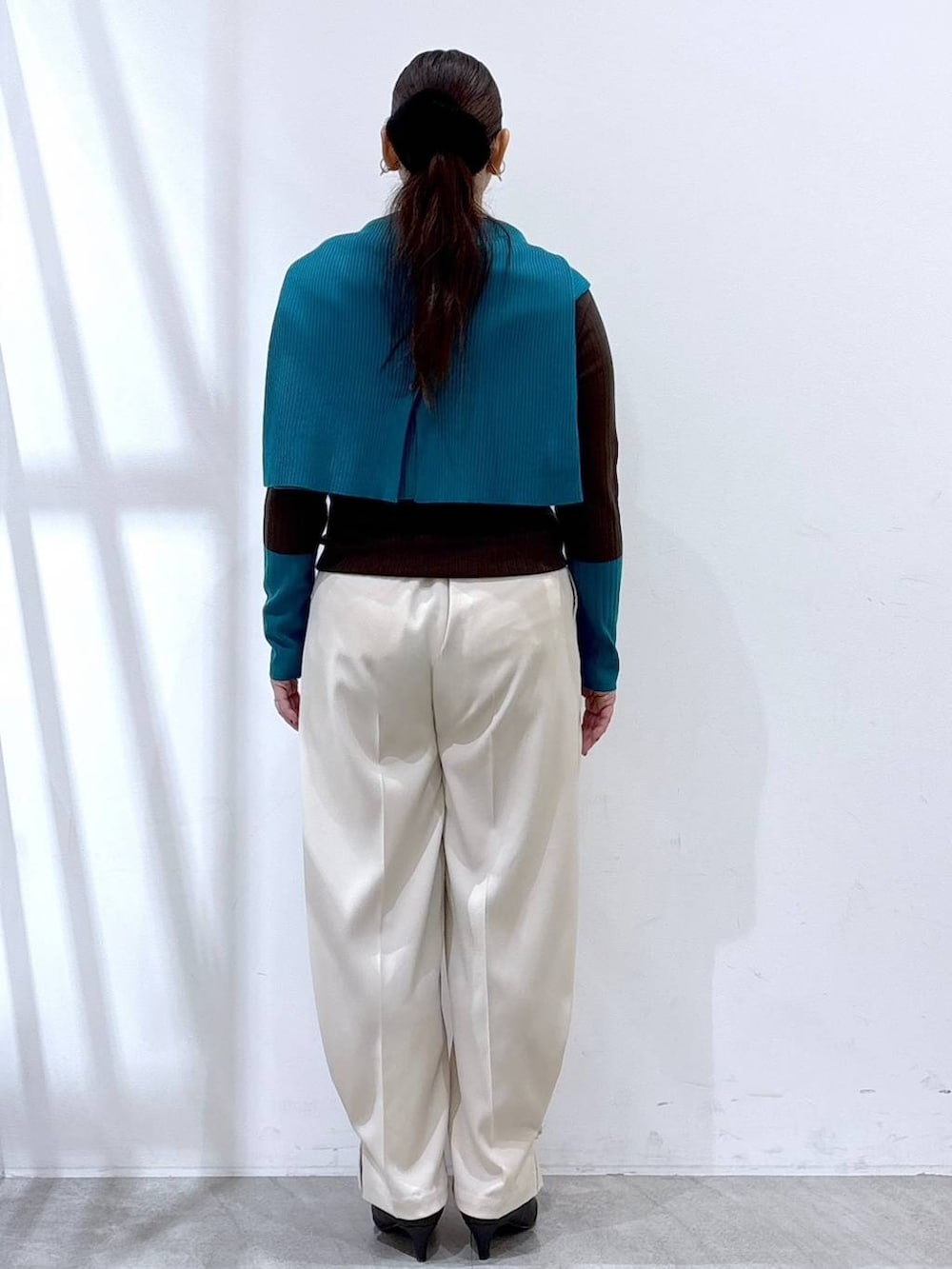 ブラック系のパンプス、ブラック系のボストンバッグ、ブラウン系のニット/セーターを着用したレディースの冬コーディネートの5枚目の写真