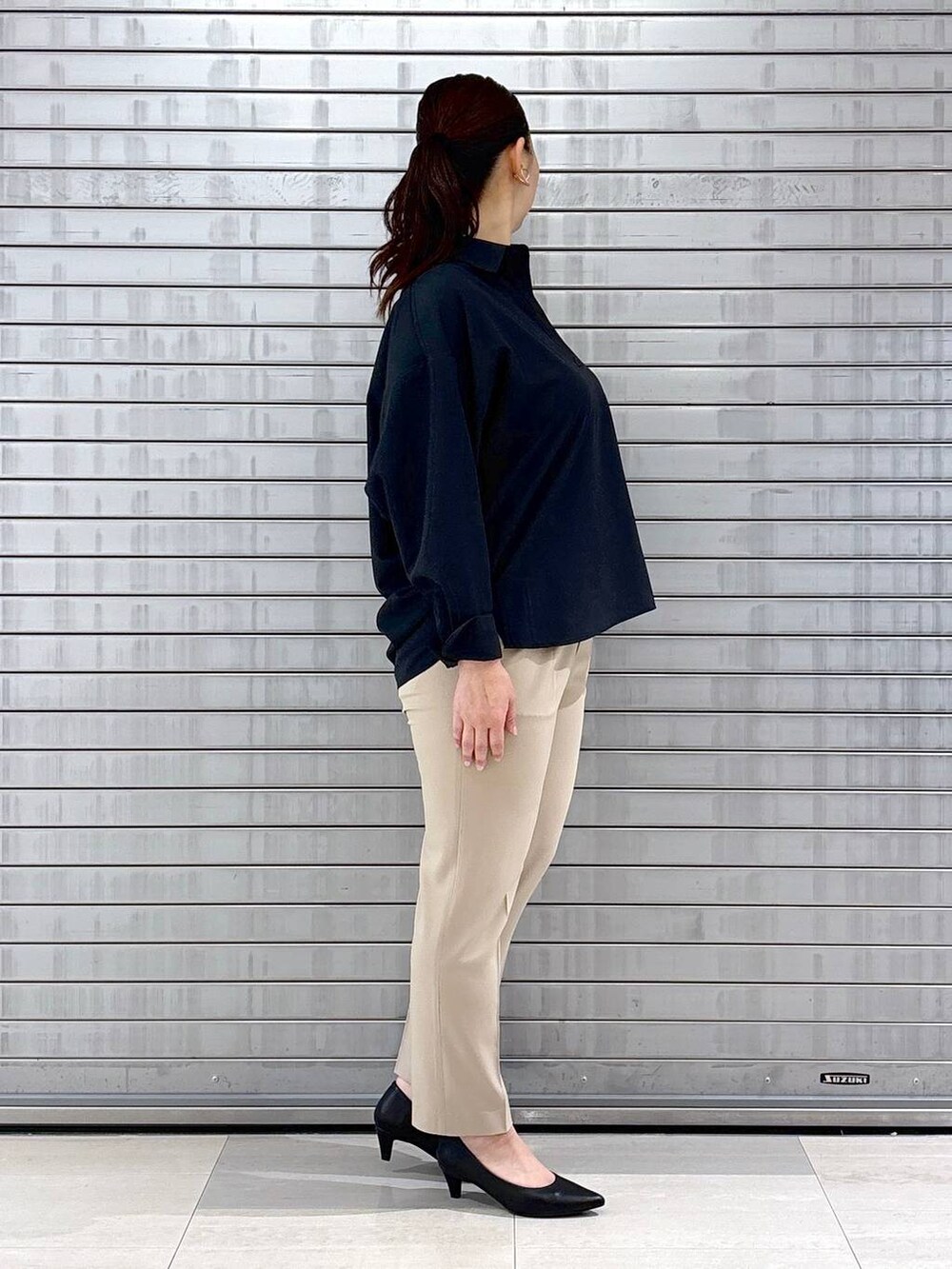 ブラック系のパンプス、ブルー系のシャツ/ブラウス、ブラック系のハンドバッグを着用したレディースの春コーディネートの5枚目の写真