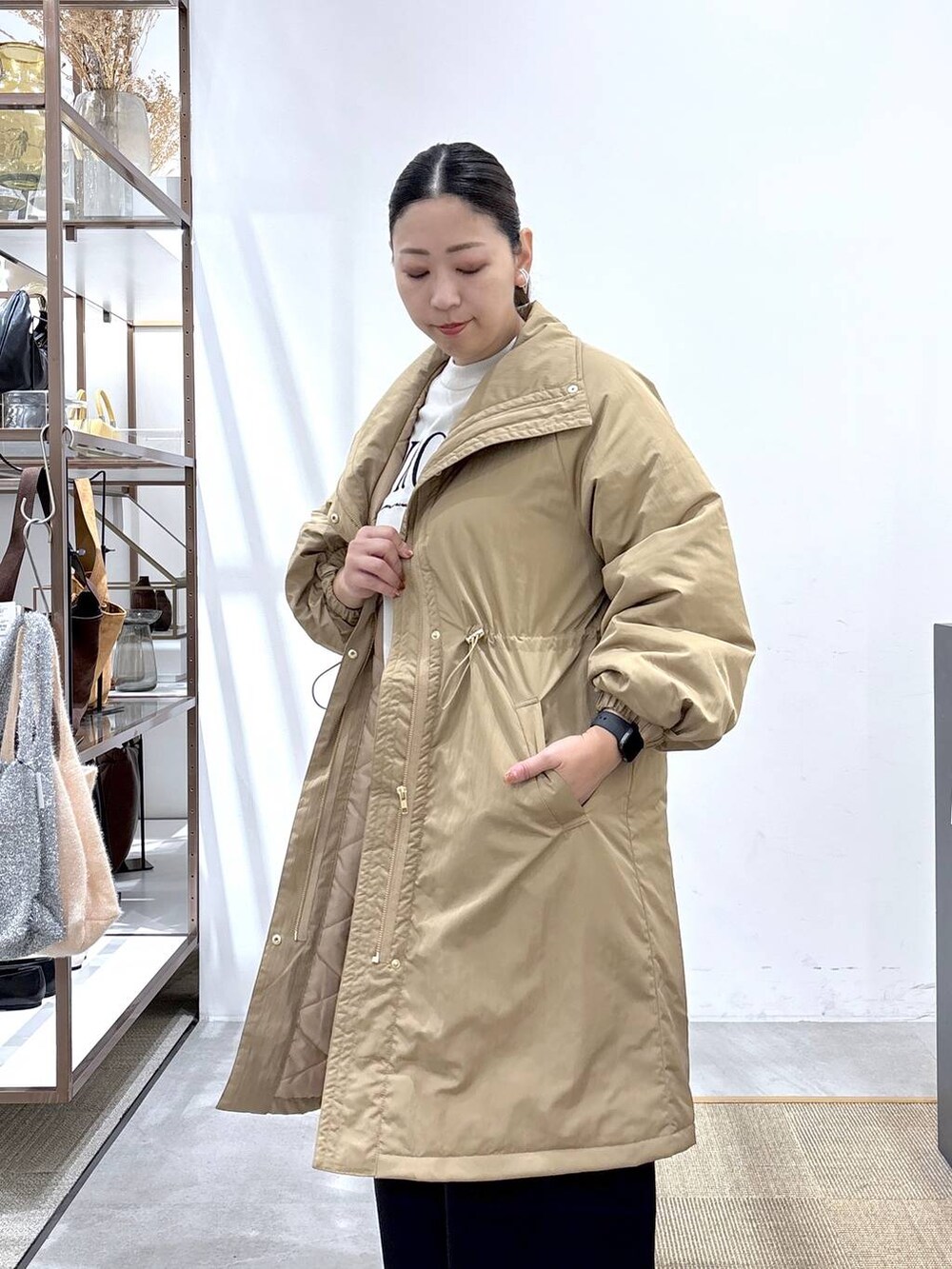 グレー系のスニーカー、イエロー系のダウンジャケット/コート、ベージュ系のTシャツ/カットソーを着用したレディースの秋コーディネートの4枚目の写真