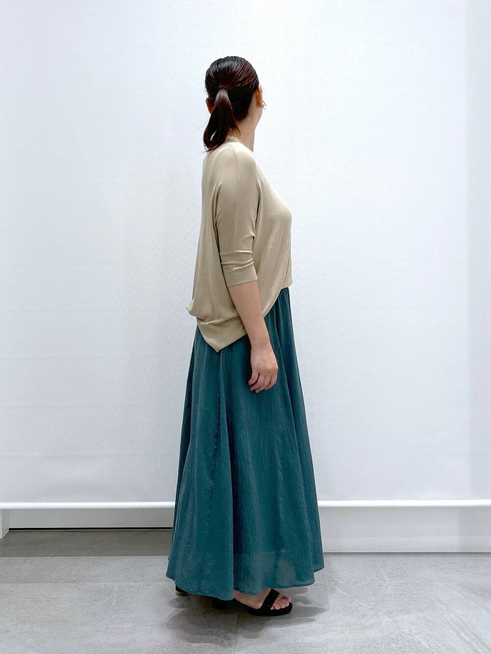 ブラック系のトートバッグ、ブラック系のサンダル、グリーン系のスカートを着用したレディースの夏コーディネートの5枚目の写真