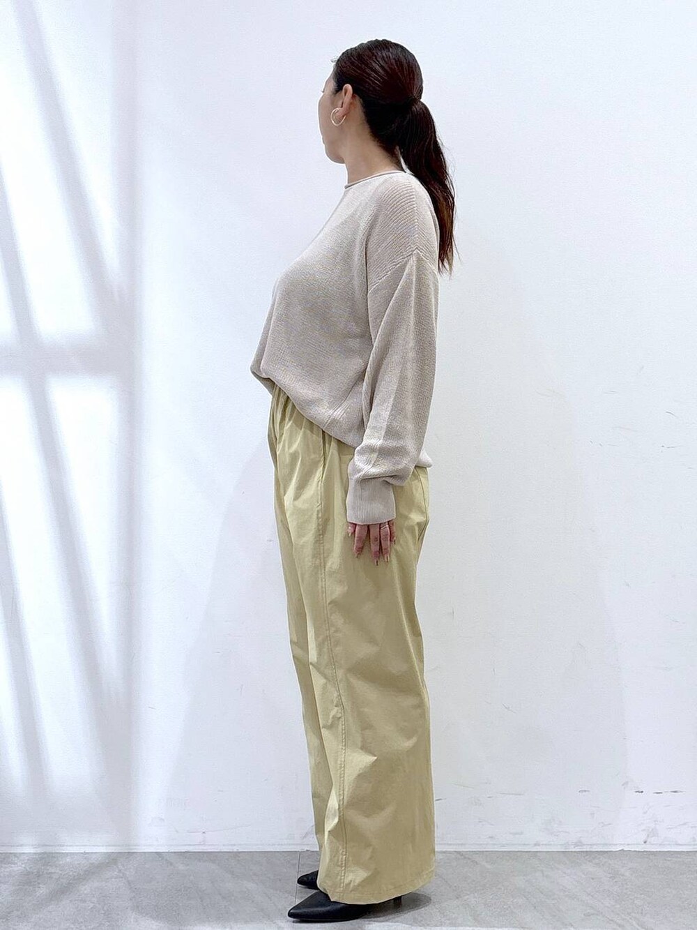 ブラック系のパンプス、ベージュ系のニット/セーター、ベージュ系のその他パンツを着用したレディースの秋コーディネートの3枚目の写真