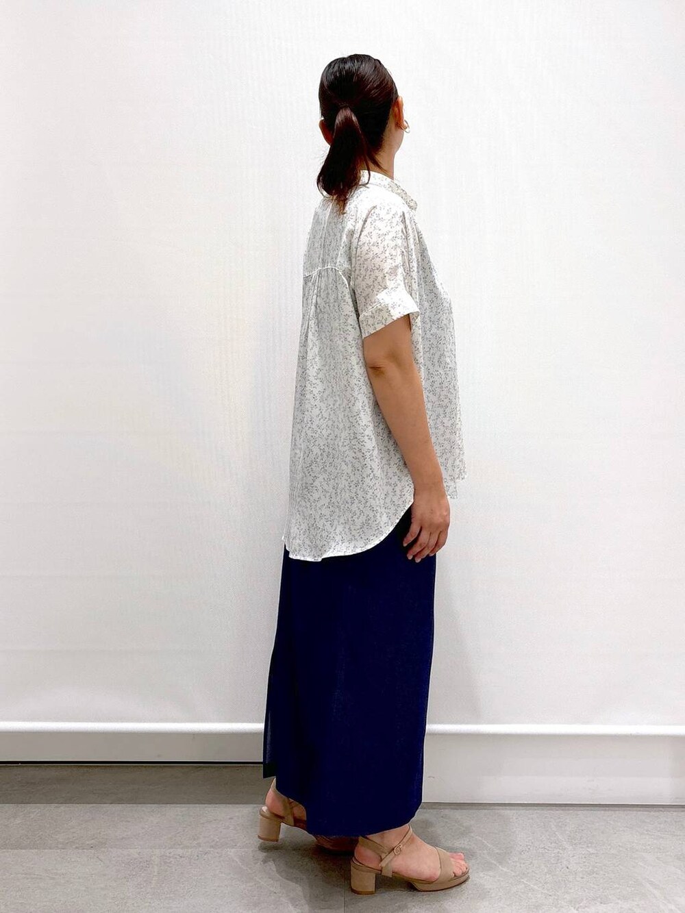 ホワイト系のシャツ/ブラウス、ベージュ系のサンダル、ブルー系のデニムスカートを着用したレディースの夏コーディネートの5枚目の写真