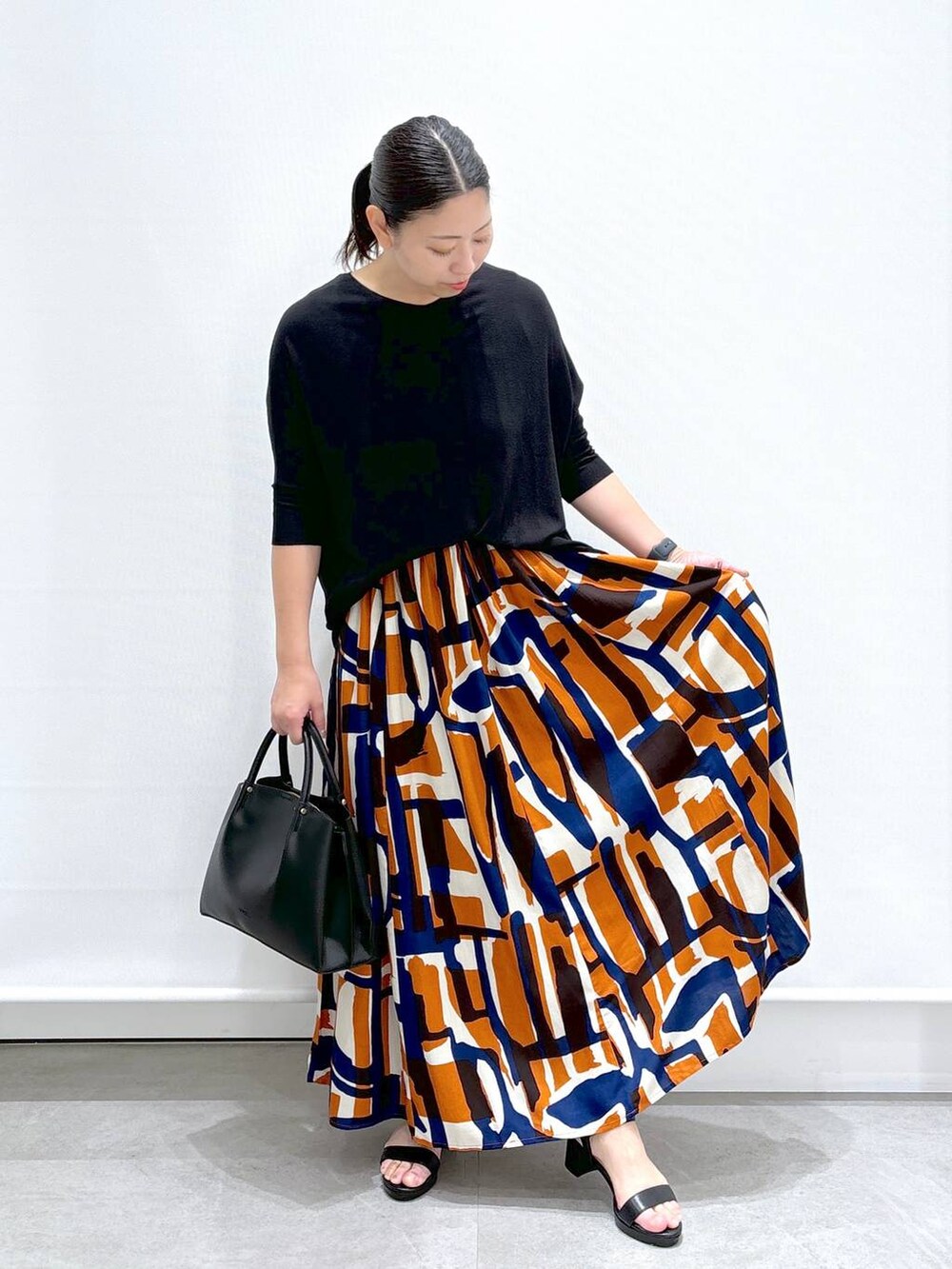 ブラック系のショルダーバッグ、ブラック系のサンダル、ブラック系のニット/セーターを着用したレディースの夏コーディネートの3枚目の写真