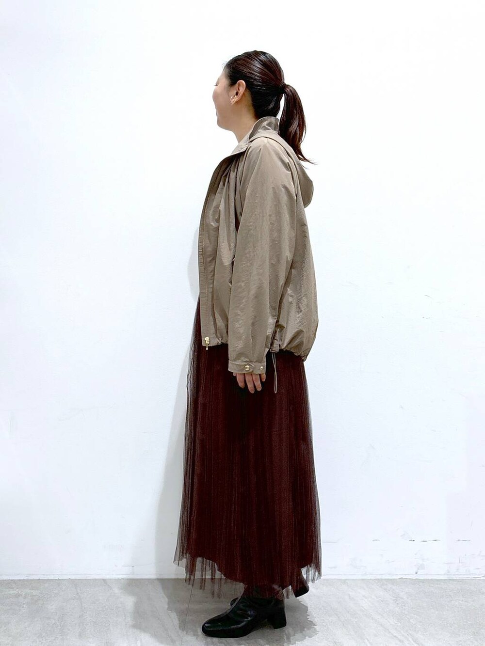 ブラック系のハンドバッグ、ブラウン系のスカート、ホワイト系のTシャツ/カットソーを着用したレディースの秋コーディネートの3枚目の写真