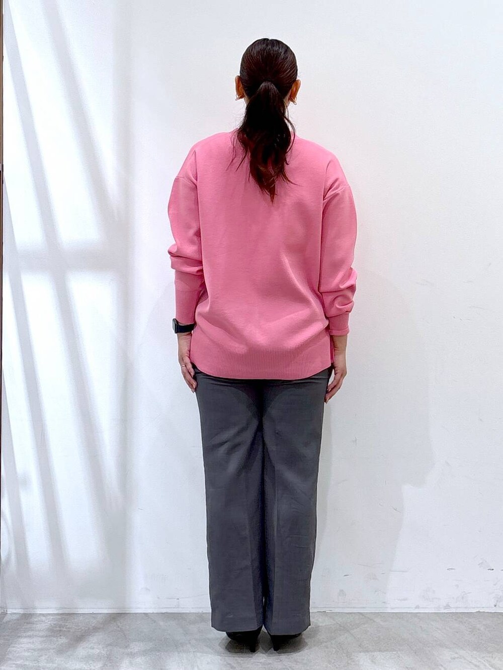 ブラック系のパンプス、ピンク系のカーディガン/ボレロ、グレー系のその他パンツを着用したレディースの秋コーディネートの4枚目の写真