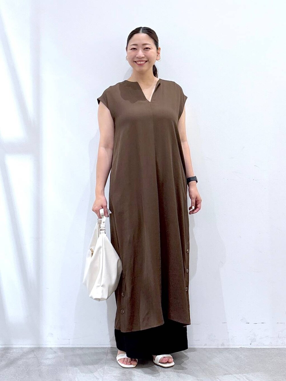 ブラック系のその他パンツ、ホワイト系のハンドバッグ、ブラウン系のワンピースを着用したレディースの夏コーディネートの2枚目の写真