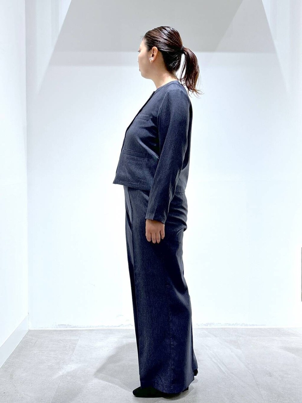 ブルー系のデニムパンツ、ブルー系のデニムパンツ、ブラック系のパンプスを着用したレディースの秋コーディネートの3枚目の写真