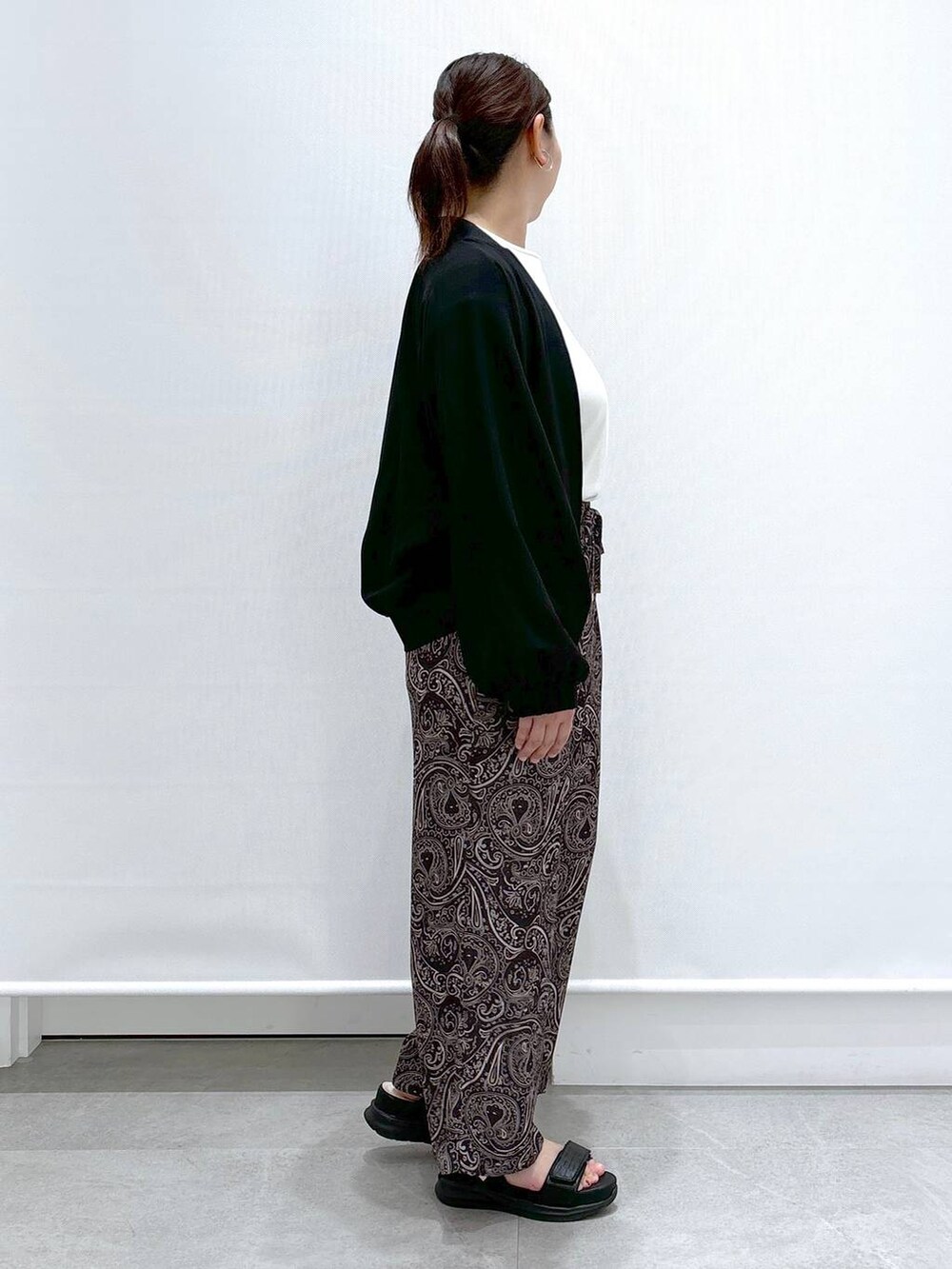 ホワイト系のTシャツ/カットソー、ブラック系のサンダル、ブラック系のブルゾンを着用したレディースの春コーディネートの5枚目の写真