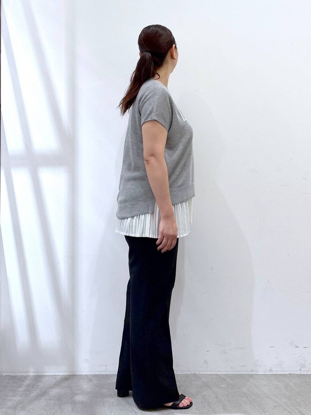 ホワイト系のタンクトップ、ブラック系のハンドバッグ、ブラック系のその他パンツを着用したレディースの夏コーディネートの5枚目の写真